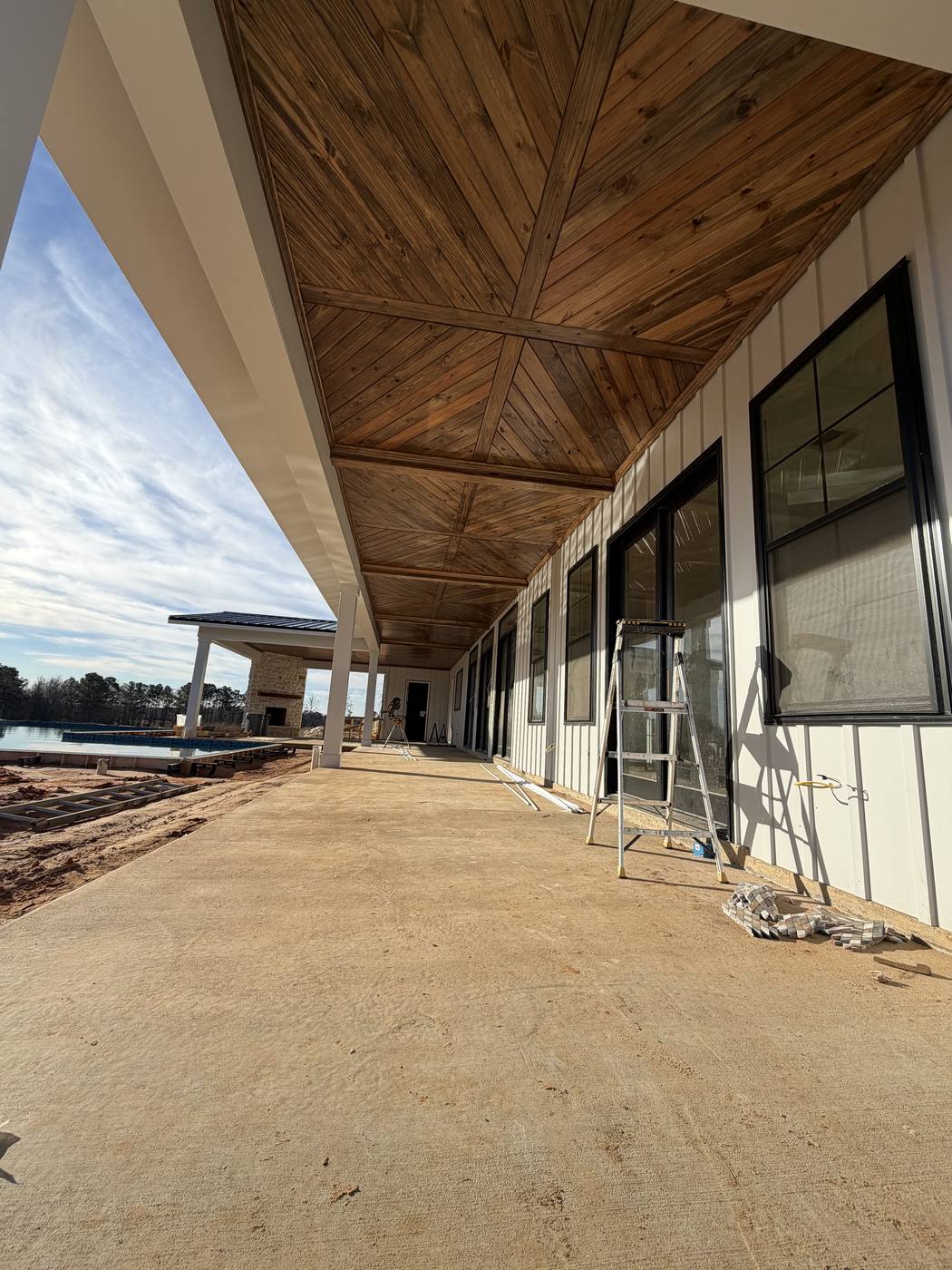 Covered back porch walkway leading to outdoor stone fireplace